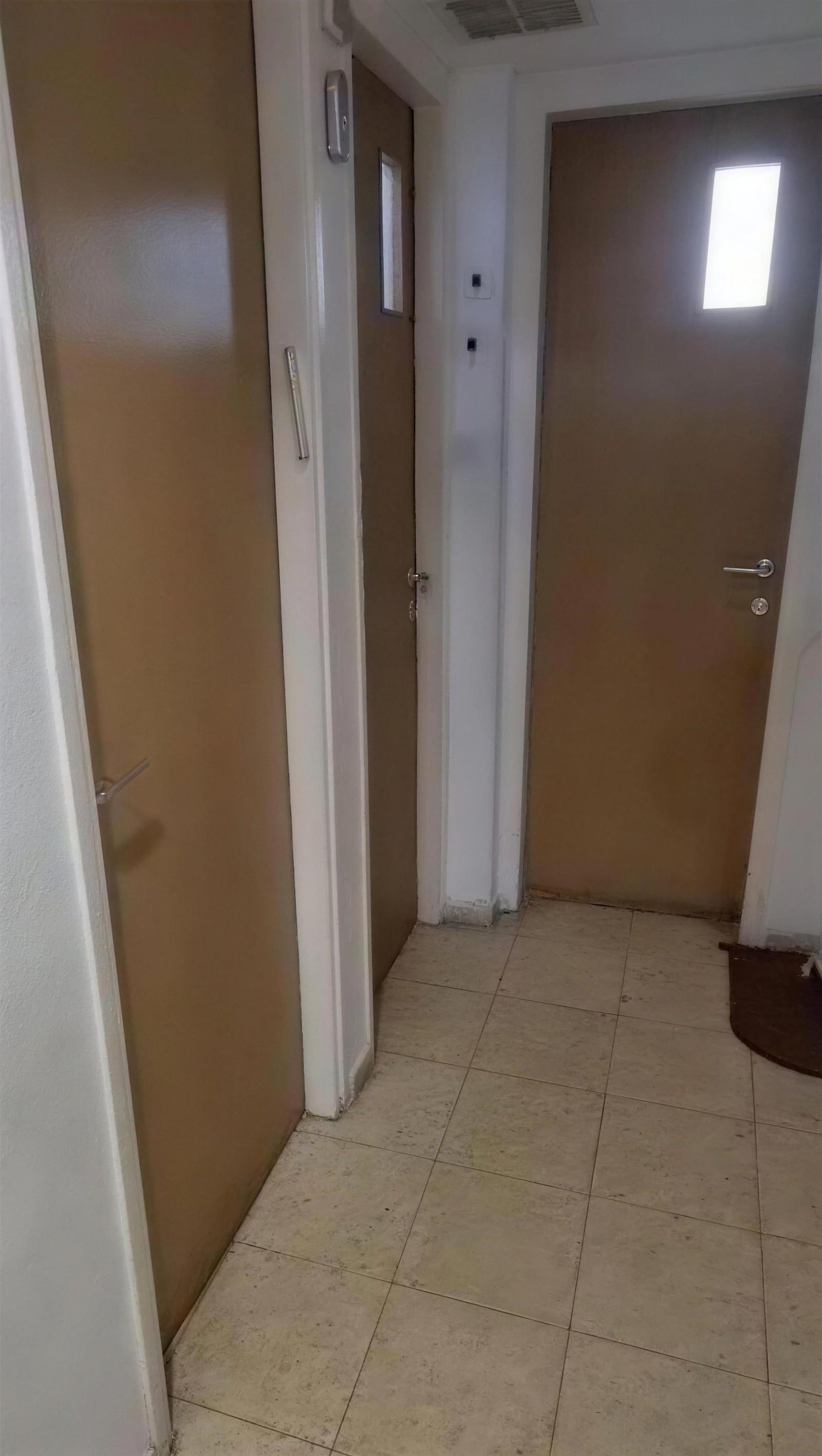 Couloir avec d’anciennes portes intérieures en bois, avant le remplacement